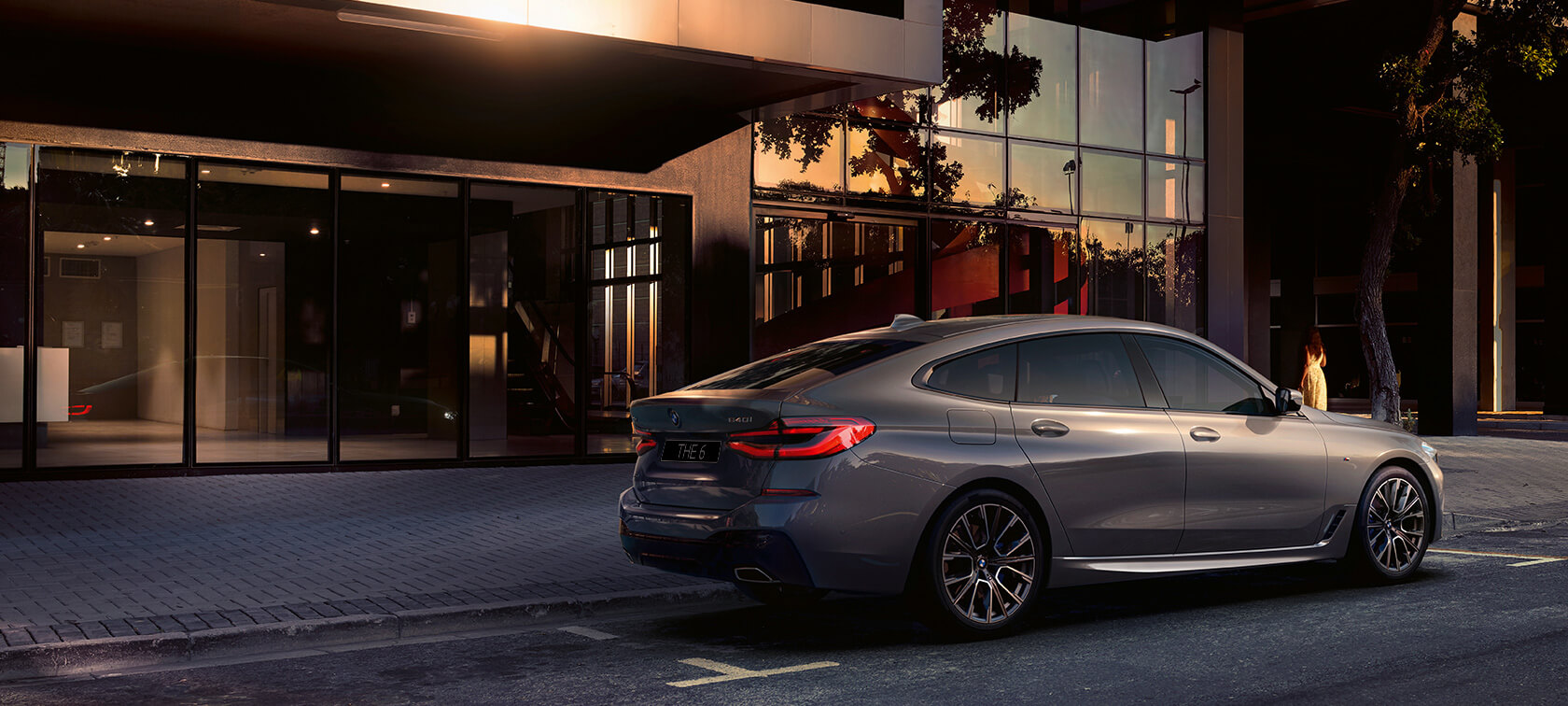 BMW 6 серии GT G32 2020 года BMW 6 серии GT 640i xDrive G32 2020 года, цвет «Серый Бернина», автомобиль припаркован перед зданием, вид сзади и сбоку