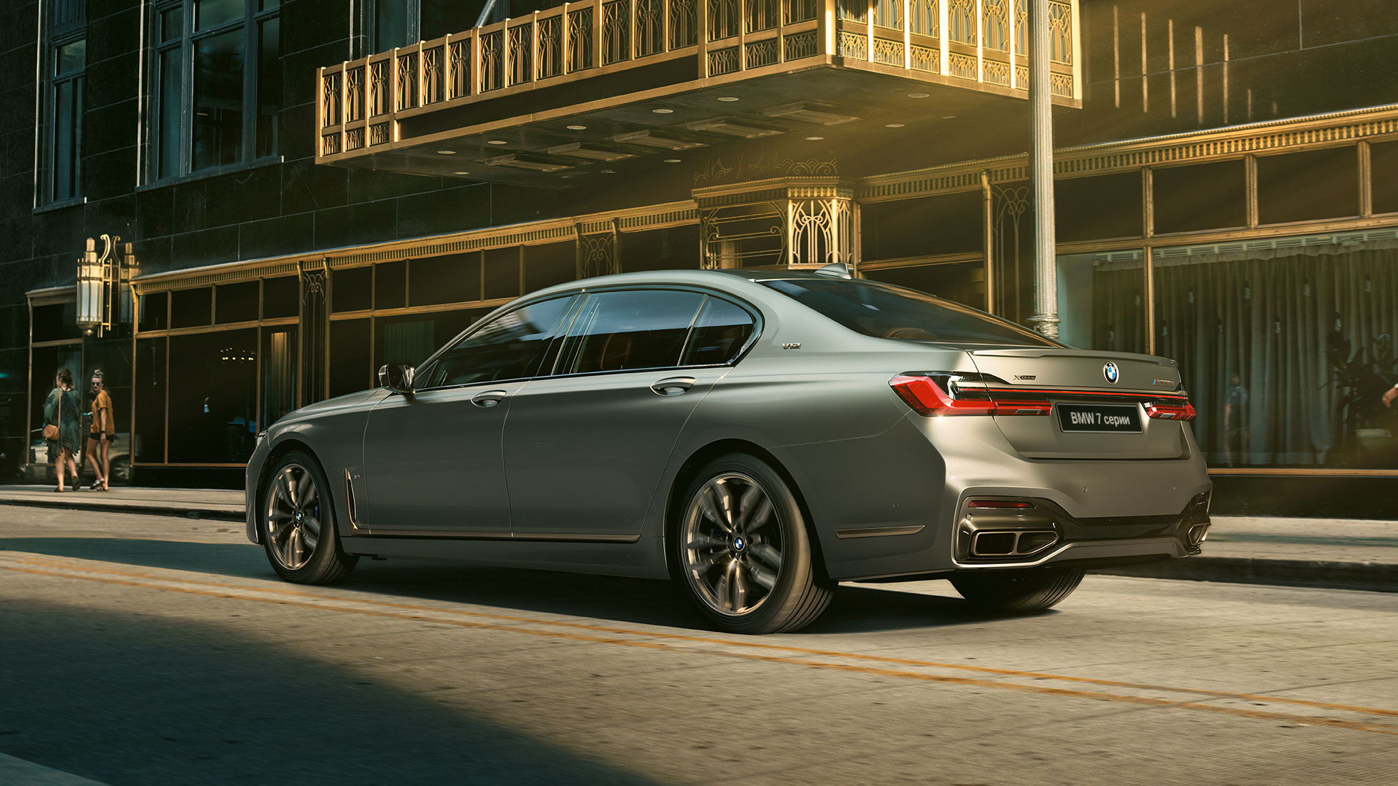 BMW M760Li xDrive с двигателем V12 BMW M760Li xDrive: вид сзади сбоку на фоне городских небоскребов