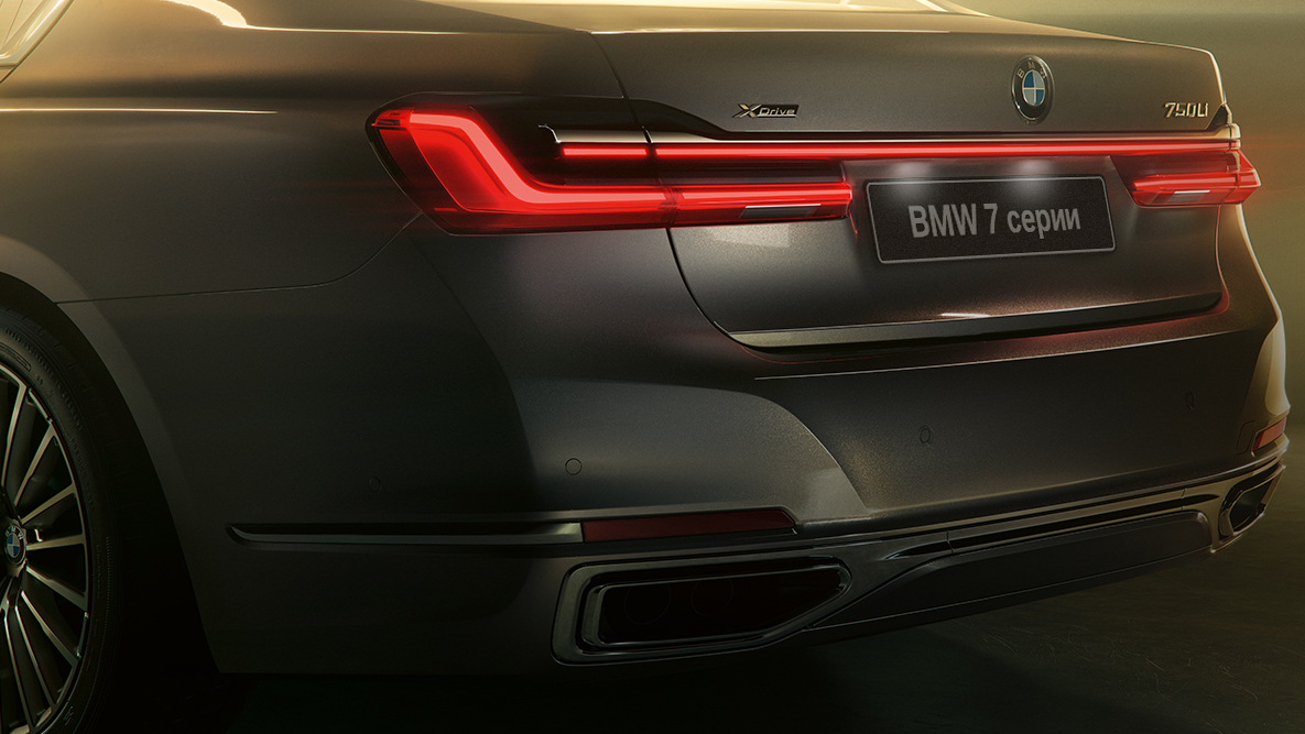 BMW 7 серии, вид спереди с поворотом в три четверти BMW 7 серии: серый BMW, вид спереди с поворотом в три четверти в окружении потоков света