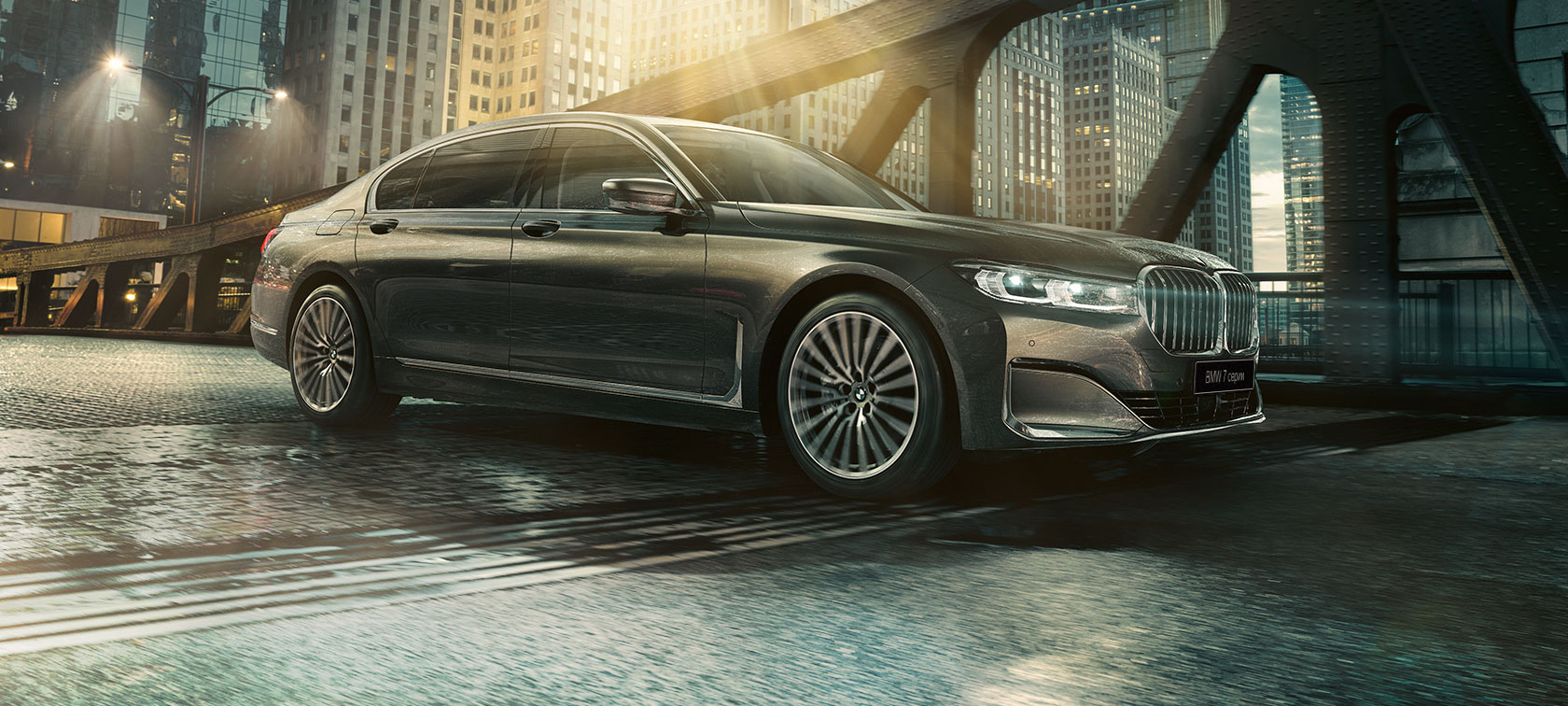 BMW 7 серии: вид сбоку BMW 7 серии: вид сбоку с открытой дверью на фоне освещенного здания гостиницы