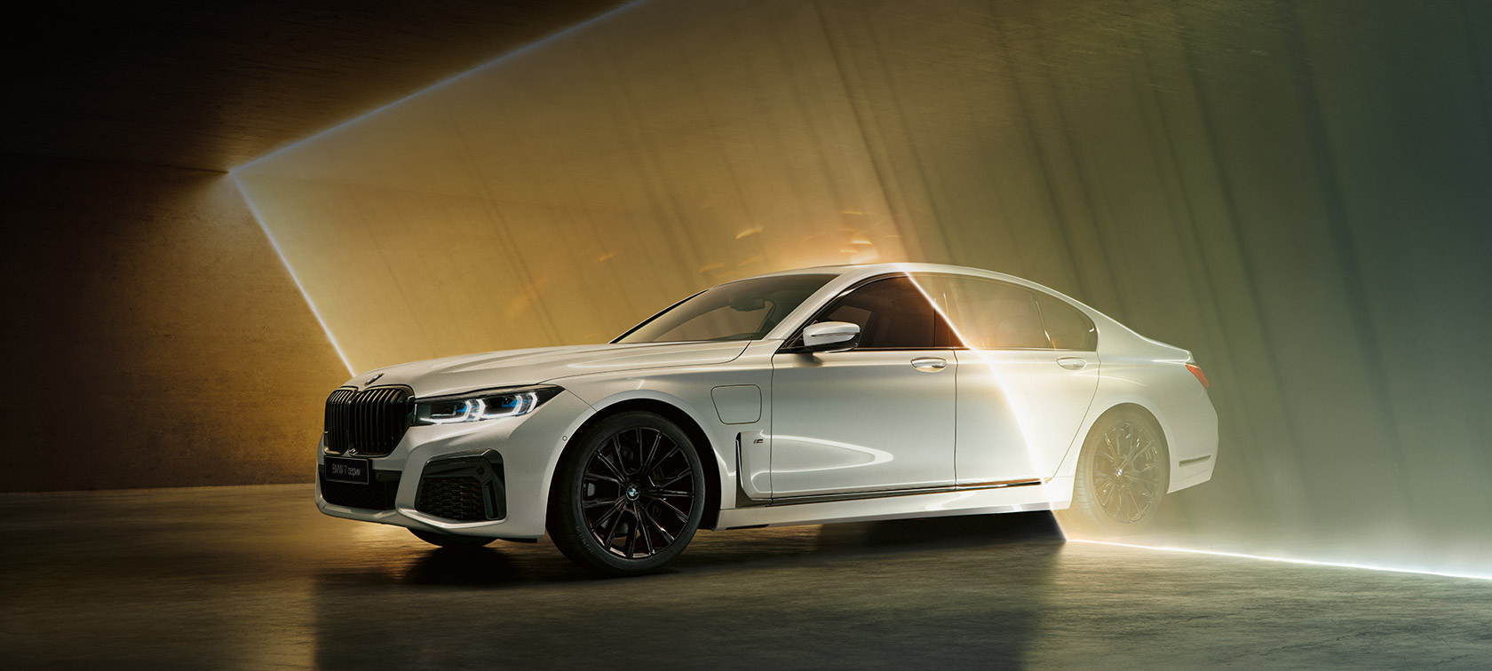 BMW 7 серии белого цвета, вид спереди с поворотом в три четверти BMW 7 серии: белый BMW, вид спереди с поворотом в три четверти в окружении потоков света