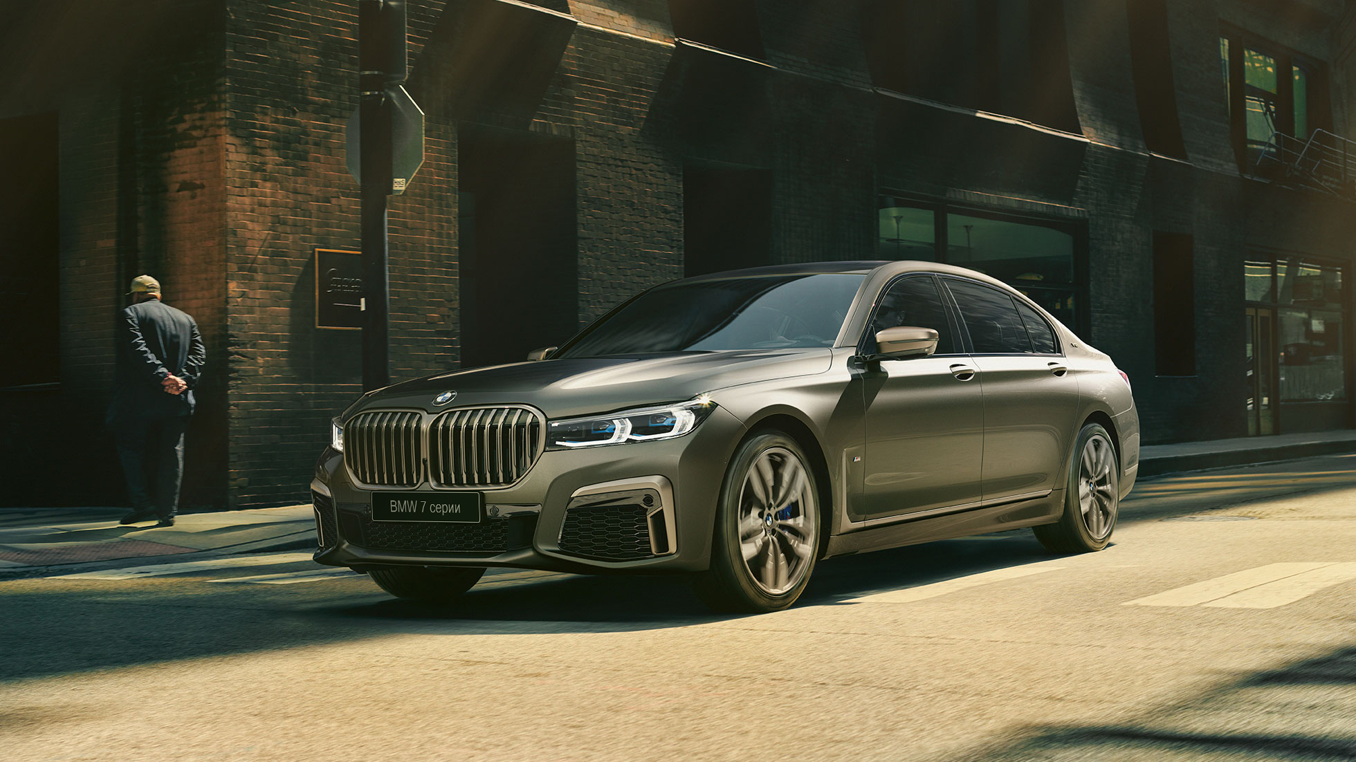BMW M760Li xDrive в городе BMW M760Li xDrive: в движении по городским улицам, вид сзади сбоку
