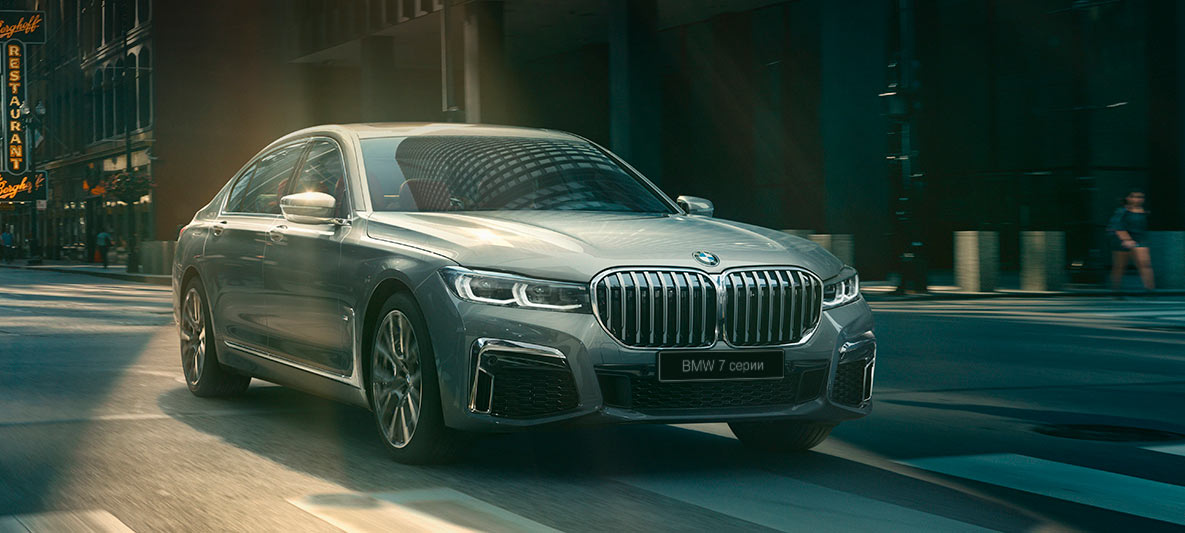 BMW 7 Series Sedan Driving Assistant Professional Driving Assistant Professional: three-quarter front view of BMW 7 Series Sedan driving in front of urban setting