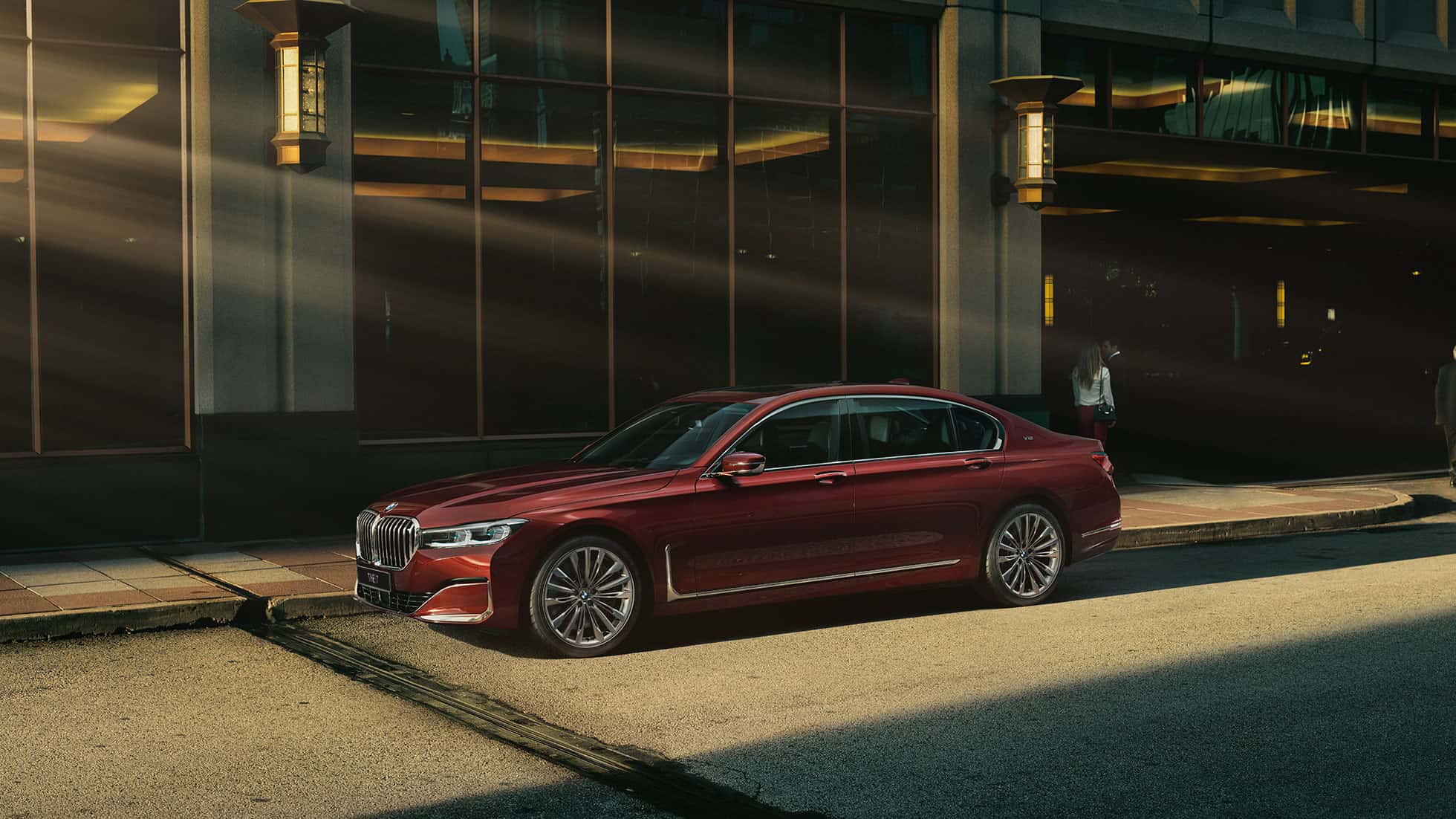 BMW 7 серии Individual: вид сбоку G11 BMW 7 серии Individual красного цвета: вид сбоку на фоне городского пейзажа G11