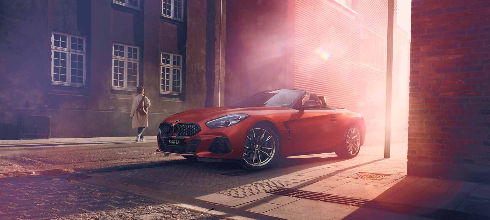 BMW Z4 First Edition красного цвета на улице BMW Z4 First Edition красного цвета на полуосвещенной улице перед домами