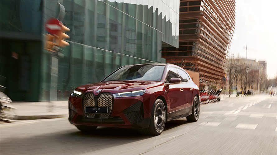 Электрический SUV BMW iX i20 2021, BMW iX xDrive50 "Красный Авантюрин" в движении в городе