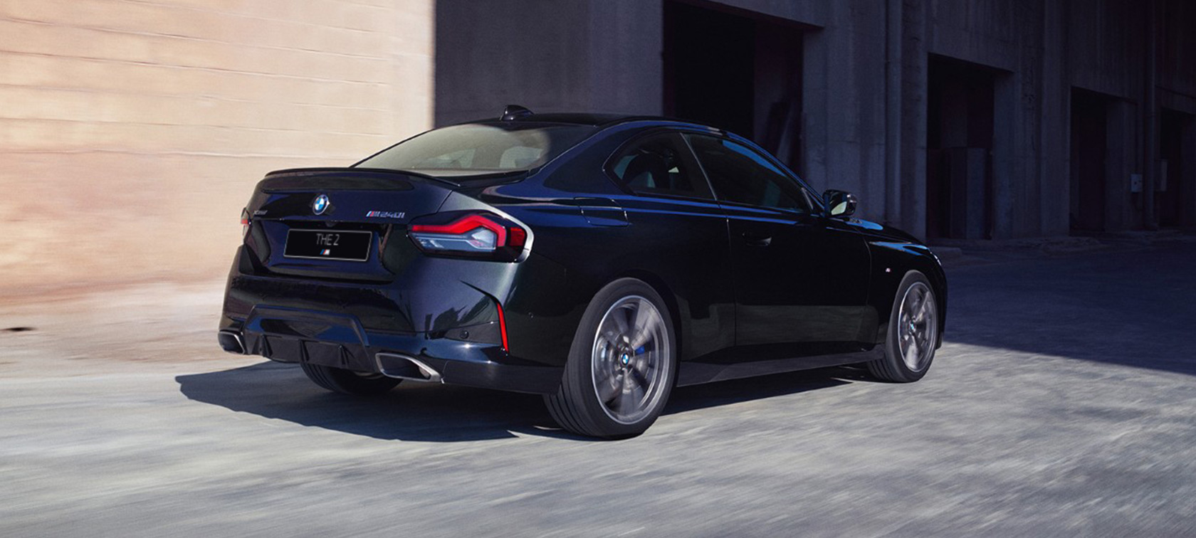 Вид сзади в три четверти BMW M240i xDrive Coupe G42 2021 BMW M240i xDrive Coupe G42 2021 "Черный Сапфир металлик", вид сзади в три четверти в движении