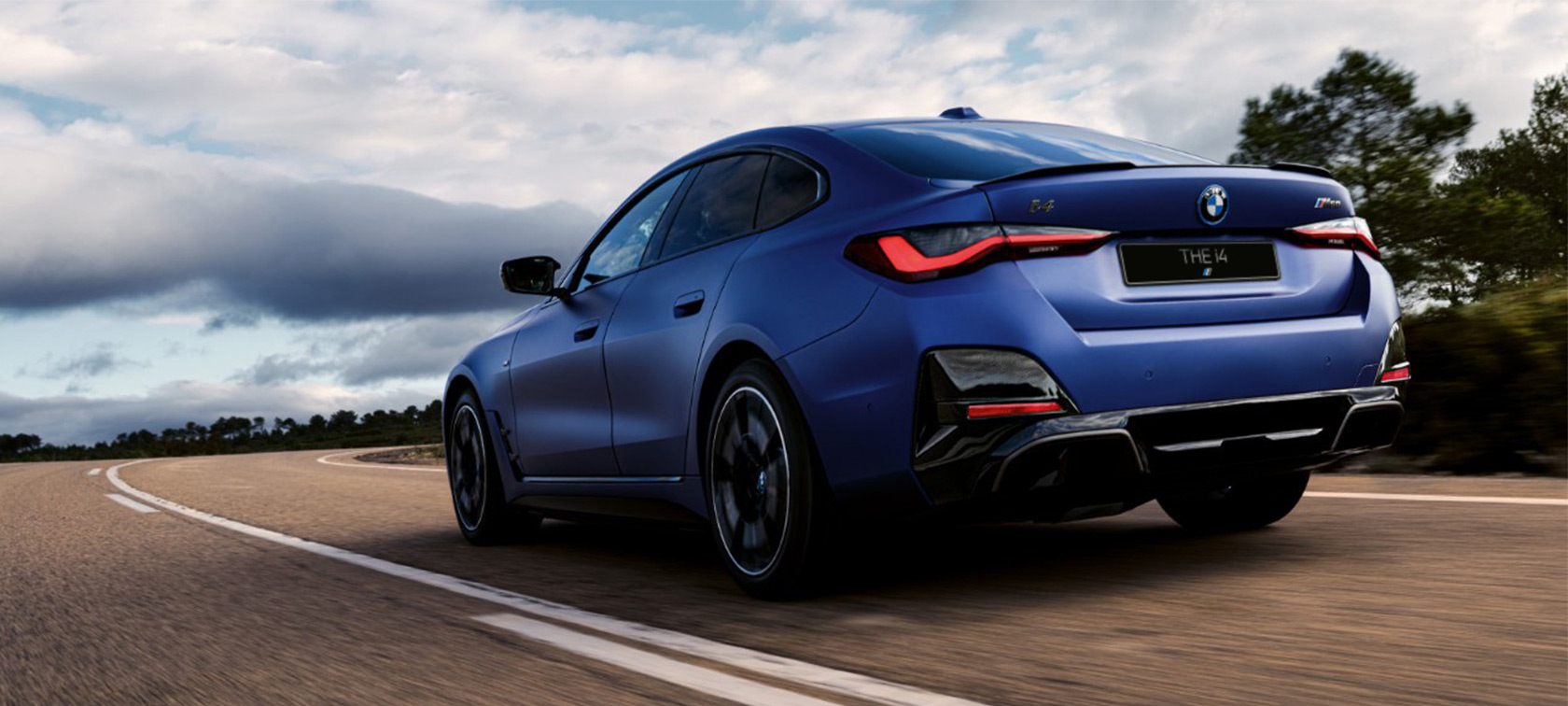 Вид сзади в три четверти BMW i4 M50 G26 2021 BMW i4 M50 G26 2021 "Морозный Синий Портимау металлик" BMW Individual, вид сзади в три четверти в движении