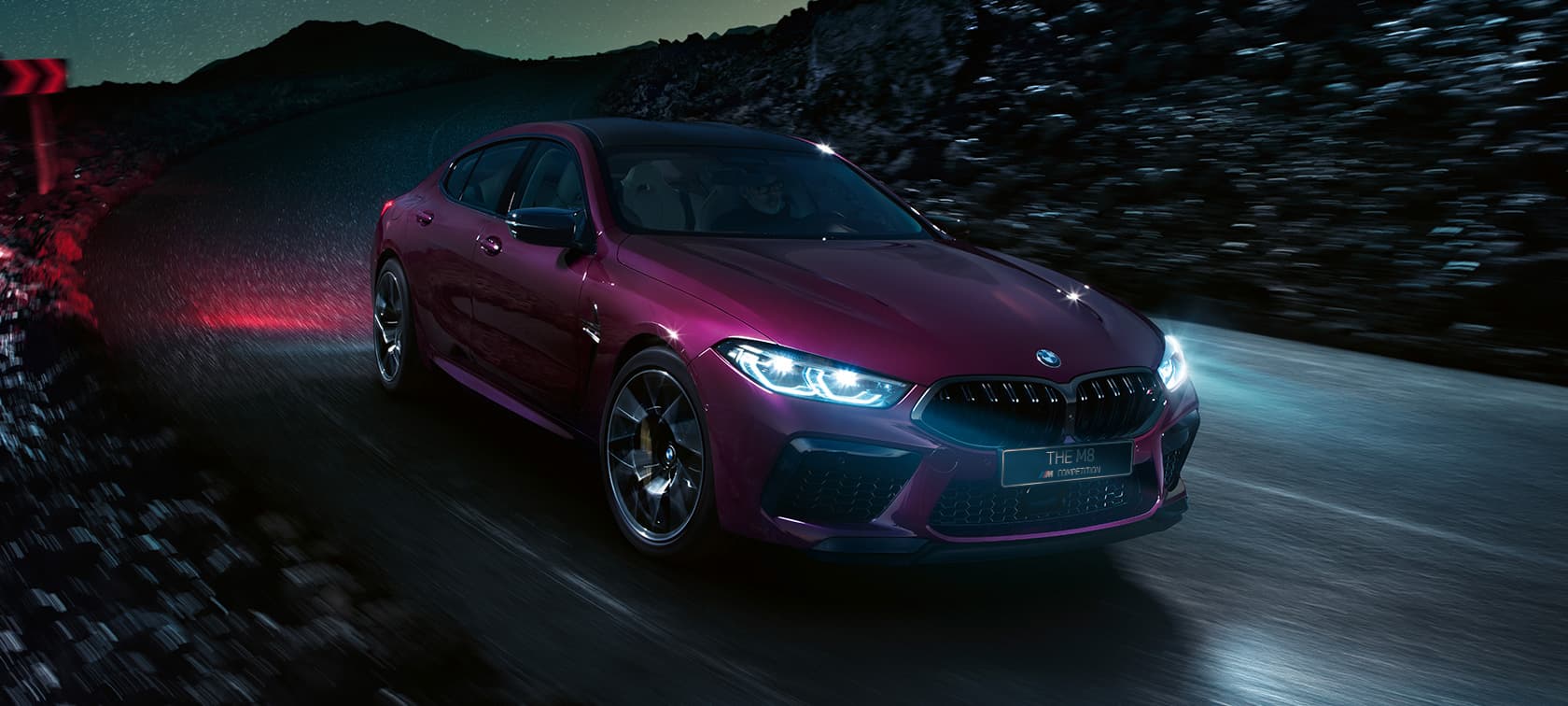 BMW M8 Competition Gran Coupe, вид спереди с поворотом в три четверти BMW M8 Competition Gran Coupe F93 2020 МГ цвета Аметрин металлик из линейки BMW Individual, вид спереди с поворотом в три четверти, в движении в ночное время
