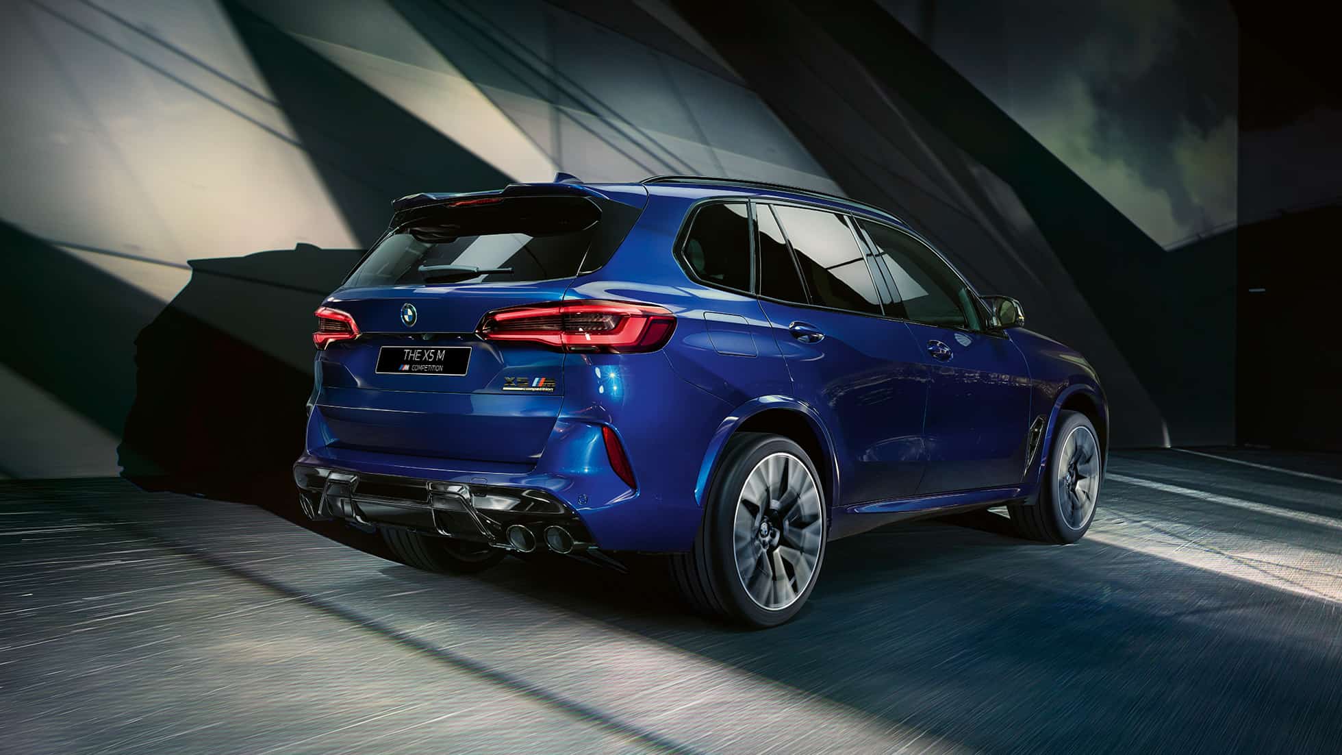 BMW X5 M Competition SUV F95 с системой M xDrive BMW X5 M Competition с системой M xDrive SUV F95 2020 МГ синего цвета Marina Bay (металлик), вид сзади с поворотом в три четверти