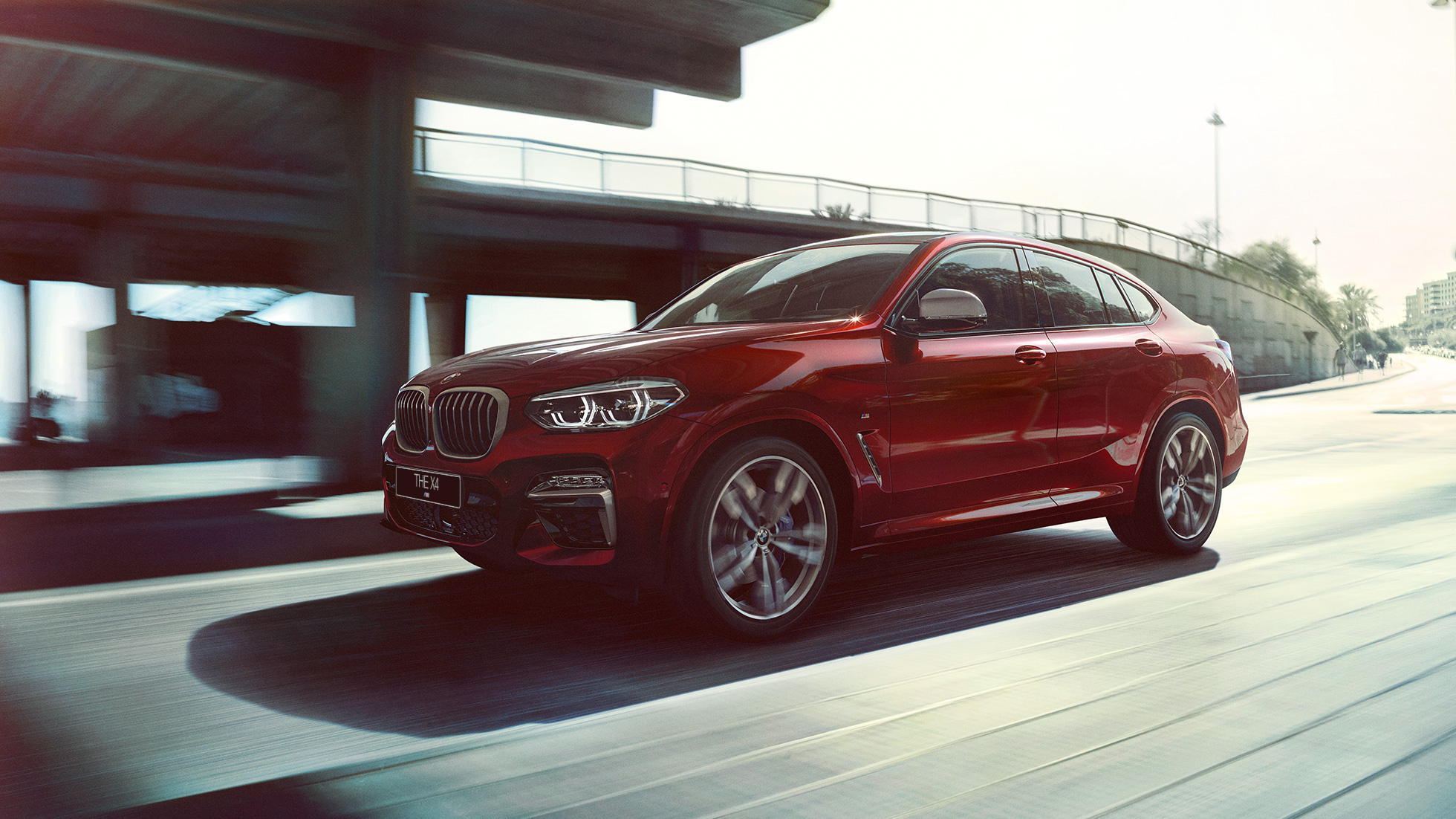 BMW X4 в динамике BMW X4 M40i G02 2018 Flamenco Red, в движении, вид три четверти