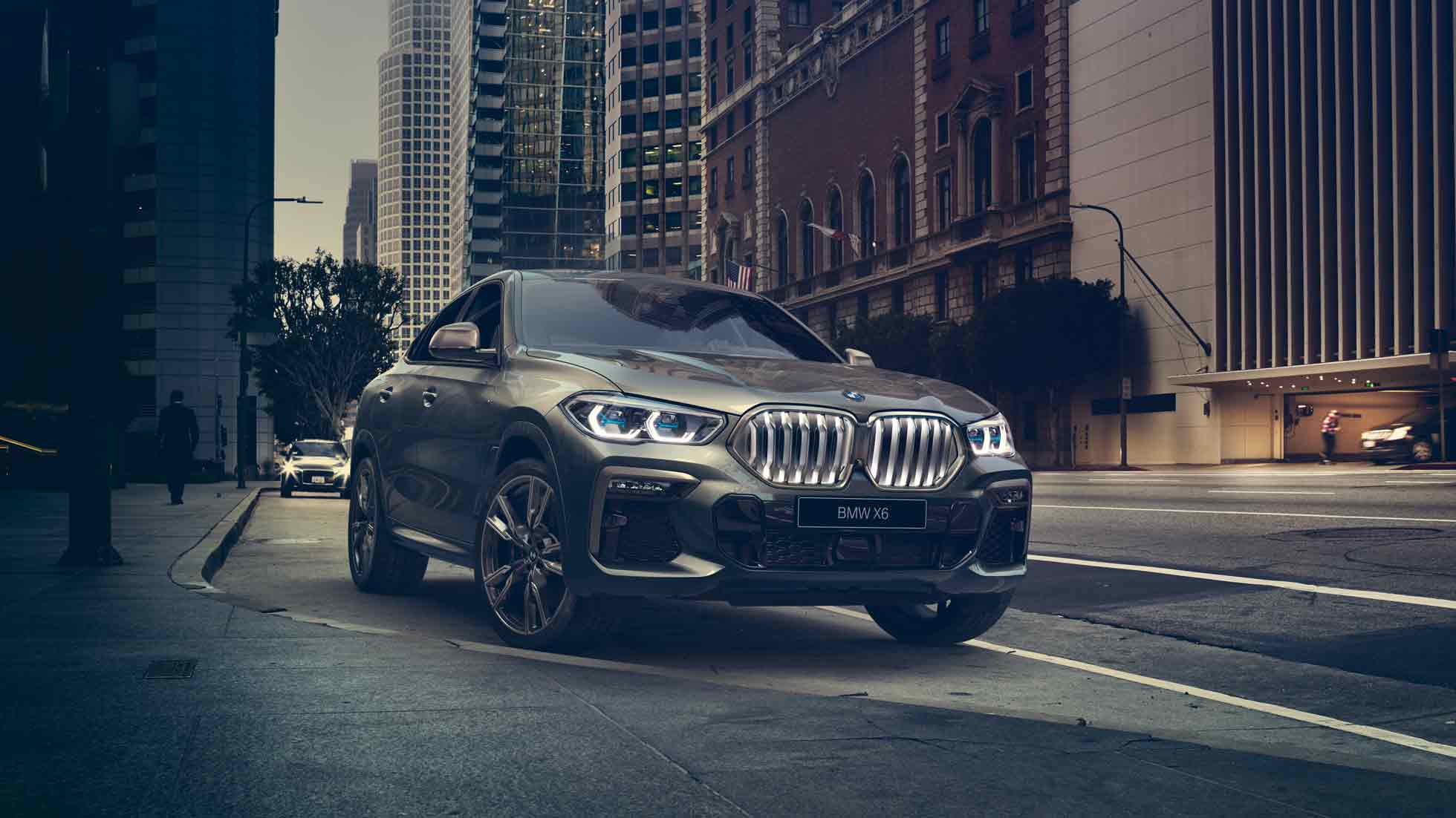 BMW X6 с адаптивной подвеской M с пакетом Professional BMW X6, вид спереди с поворотом в три четверти на фоне города