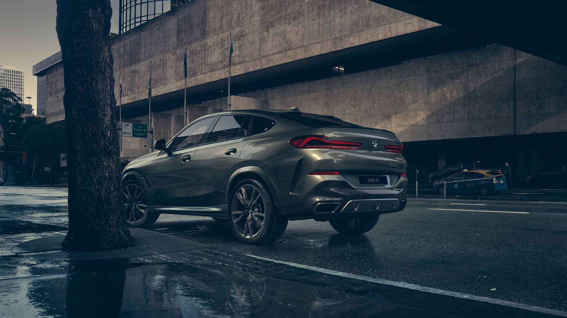 Экстерьер BMW X6 BMW X6, вид сзади с поворотом в три четверти на фоне города