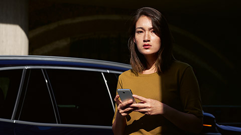 Обзор BMW ConnectedDrive BMW ConnectedDrive, обзор цифровых сервисов, женщина со смартфоном перед BMW