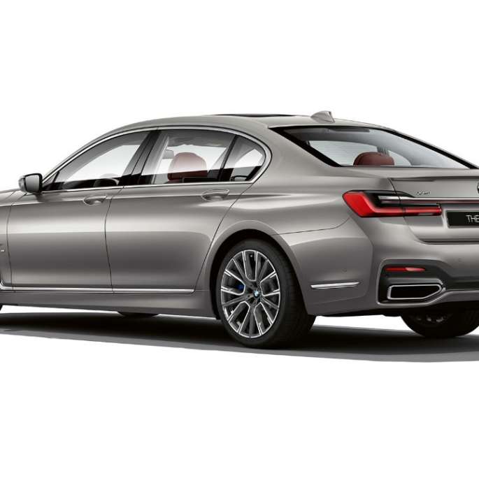 BMW 7 серии серого цвета с пакетом M Sport, вид сзади с поворотом в три четверти G11